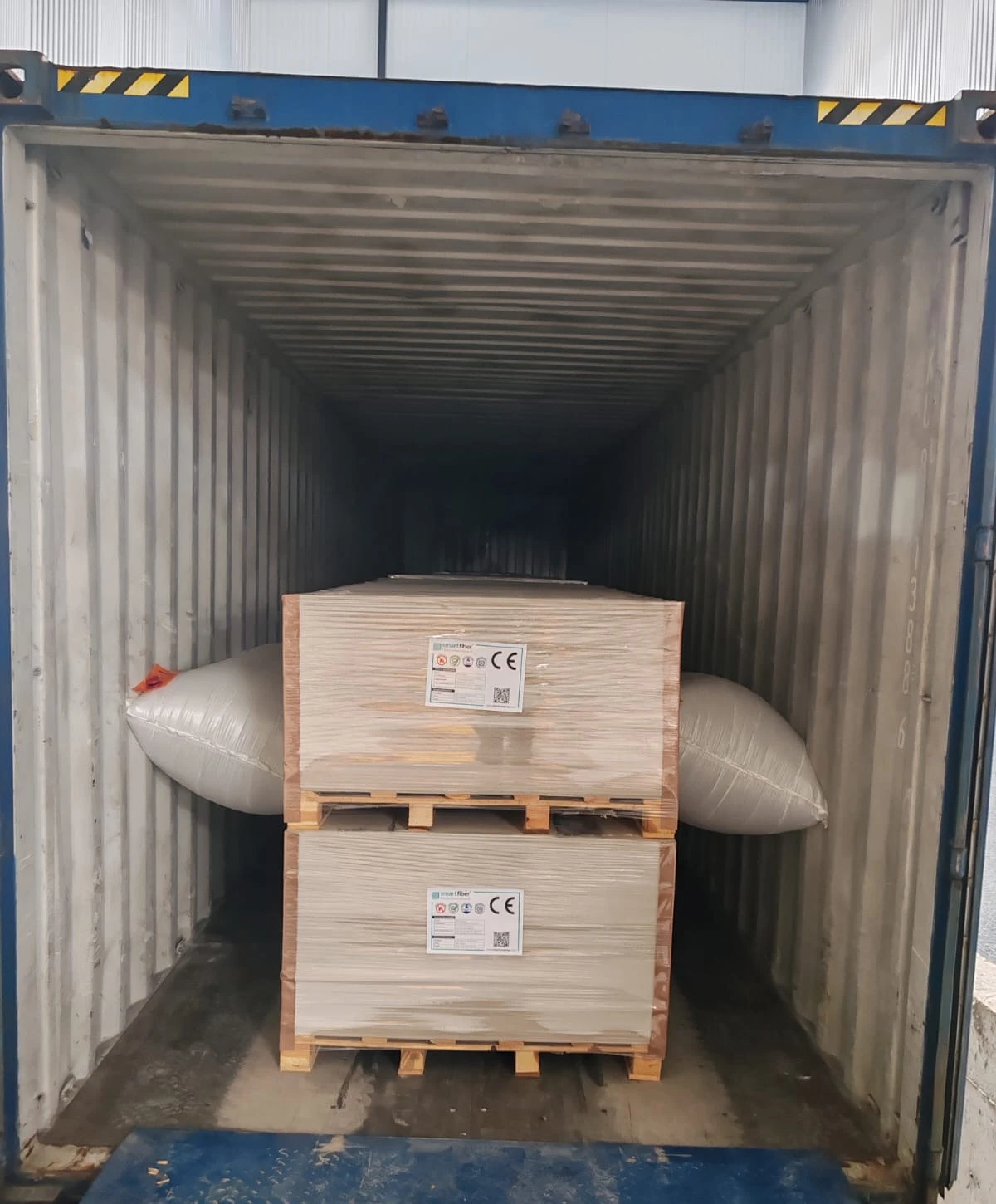 Smartfiber-labelled pallets secured with protective dunnage inside an export shipping container.