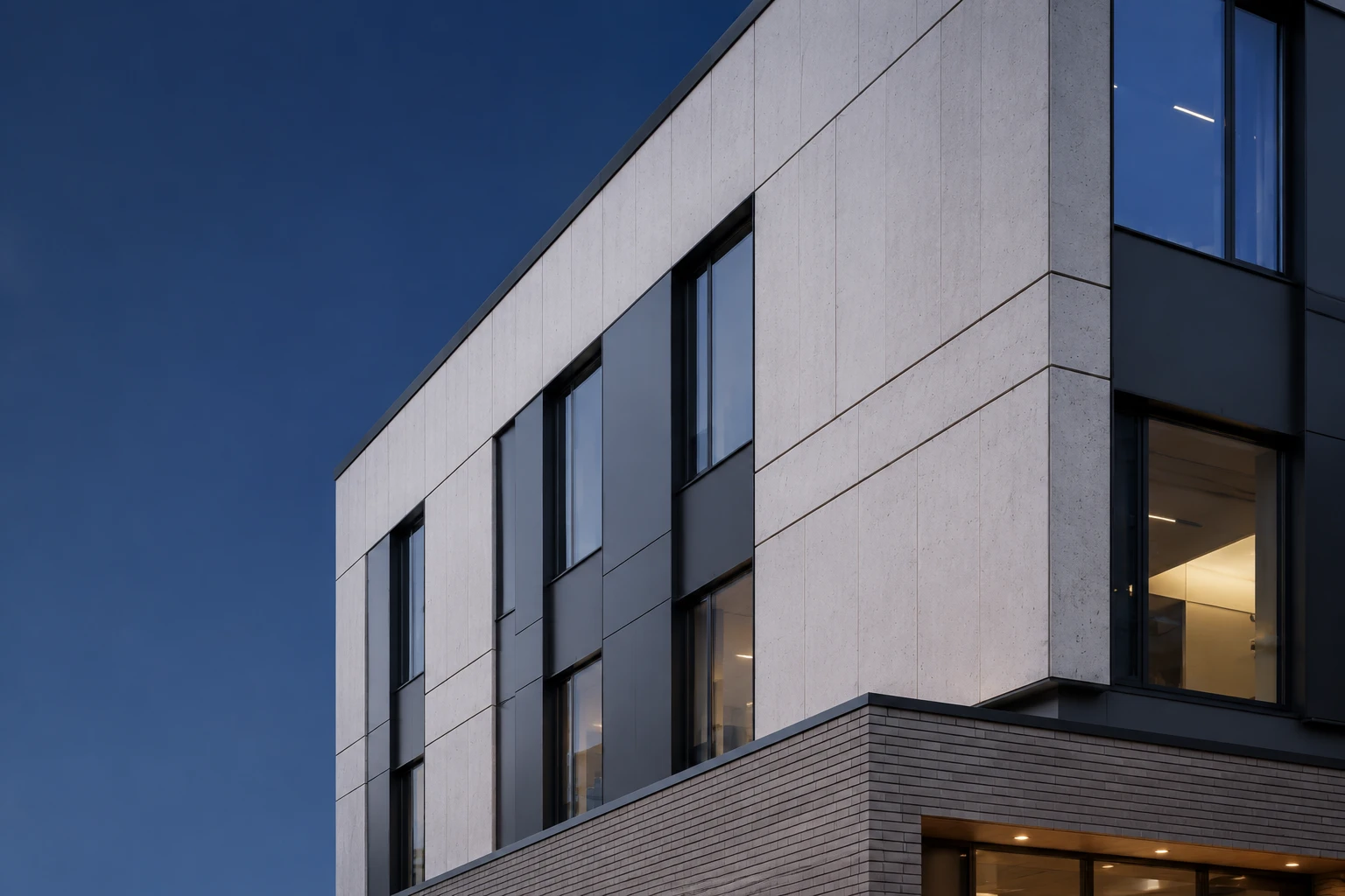 Contemporary Nordic building façade combining pale mineral panels, charcoal aluminium detailing and muted brick finishes