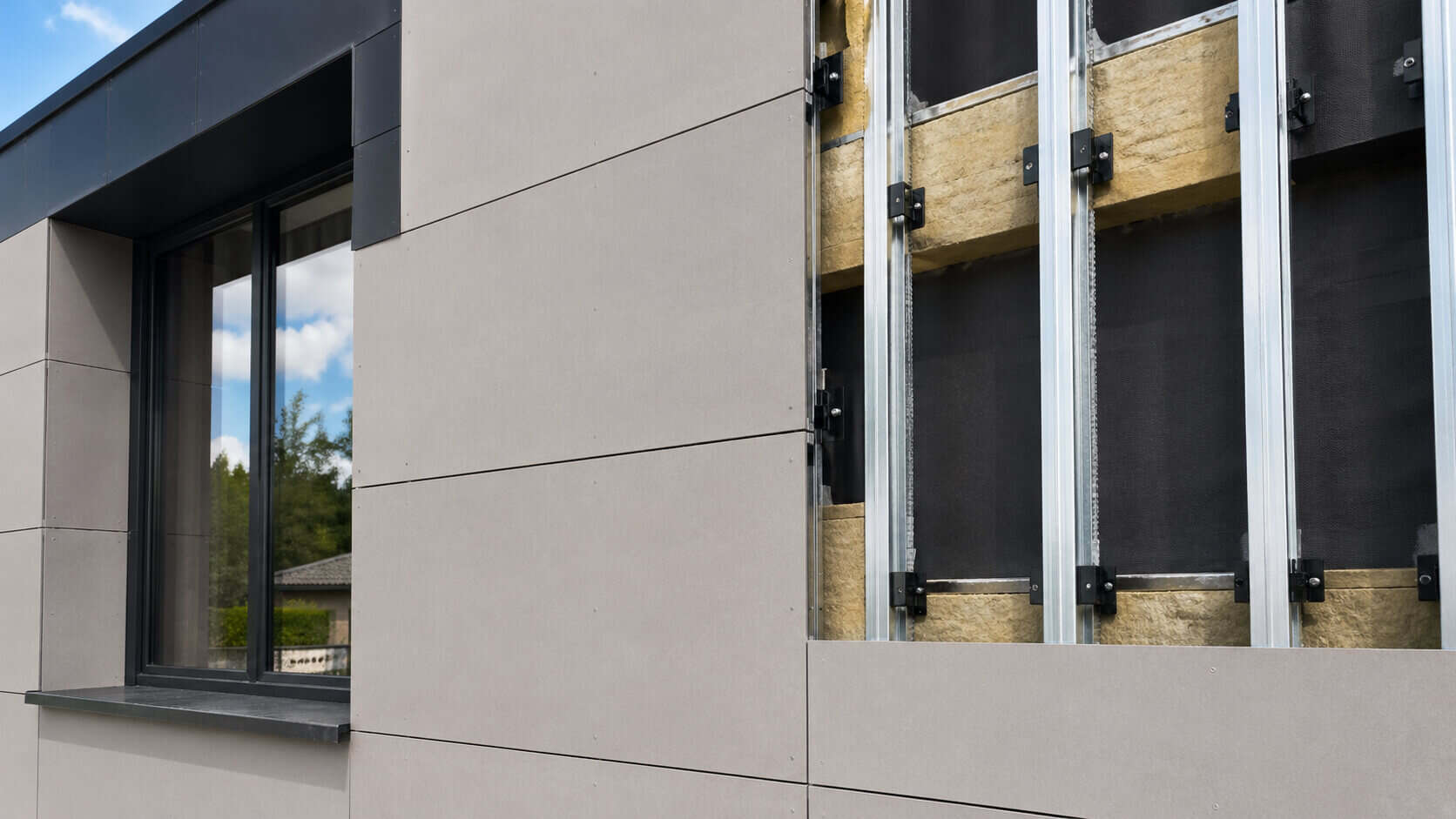 Fiber cement board façade with visible ventilation gap, support rails, insulation, and backing layer behind the panels.