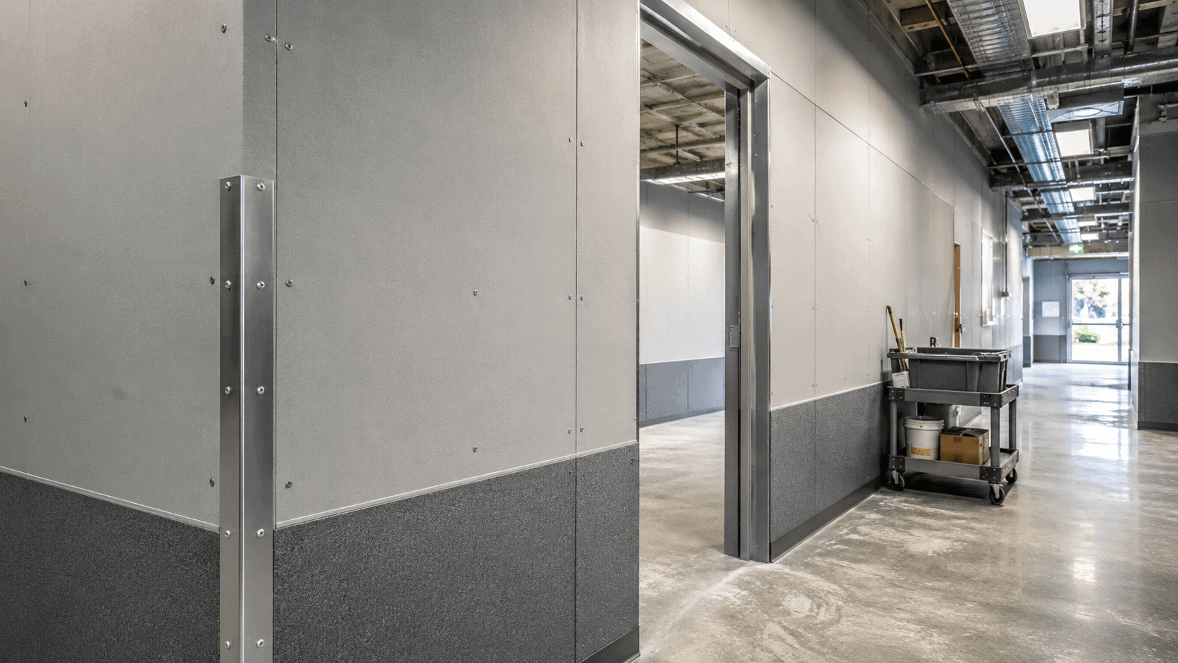 Fiber cement board installed in a high-traffic area with corner protection, lower wall protection, and strong screw fixing.